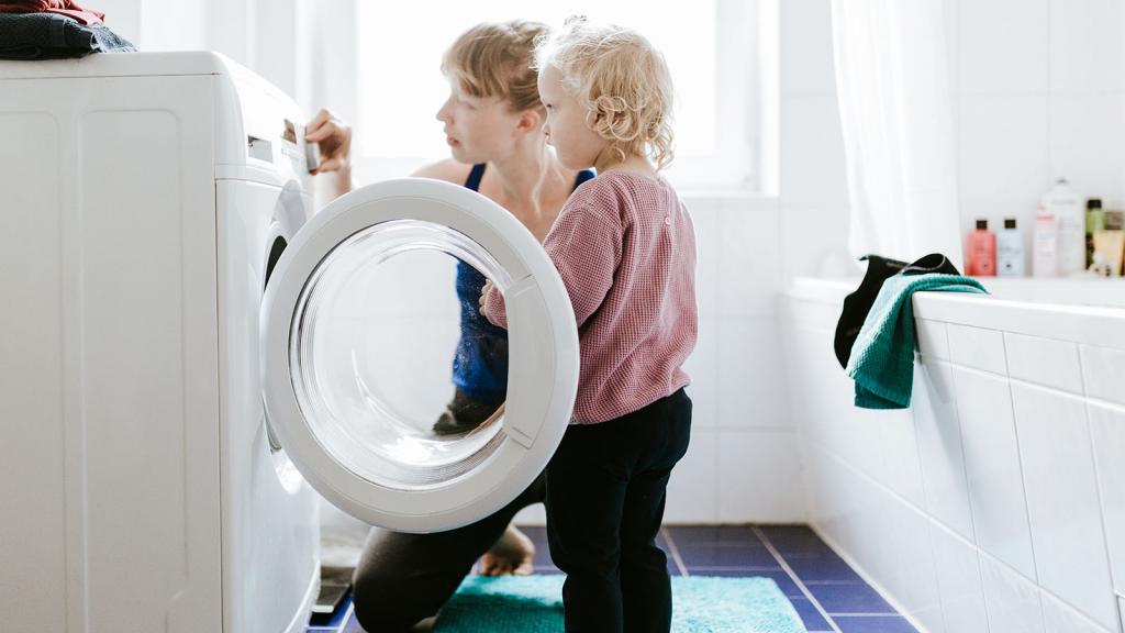 Frau und Kind vor Waschmaschine im Bad